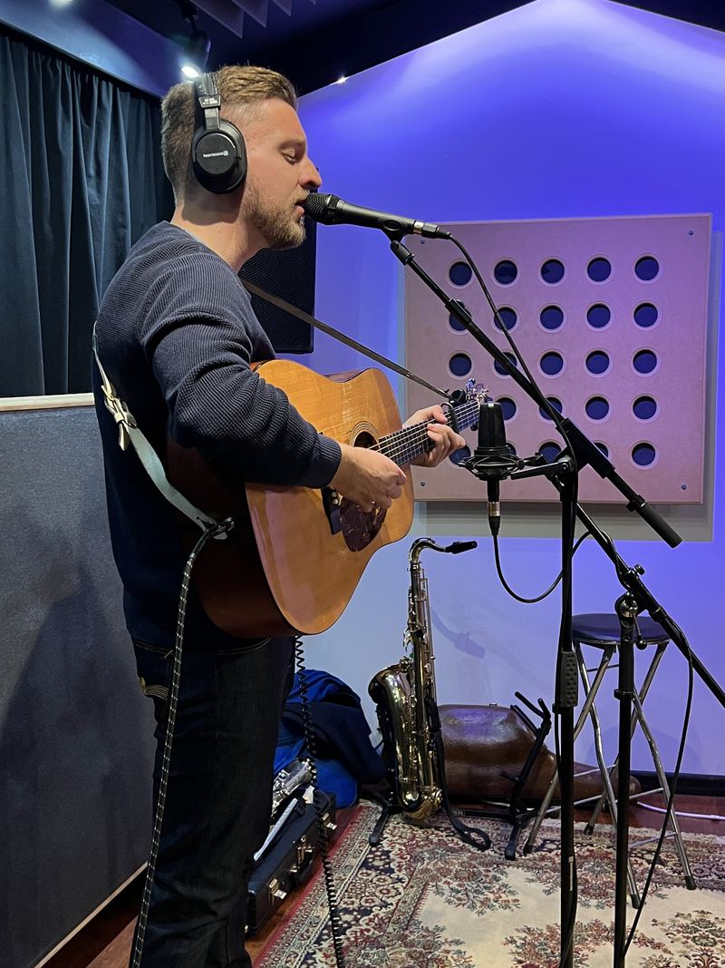 Tom recording vocals and acoustic guitar in a studio